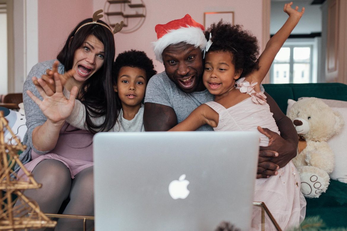 family sitting in front of a laptop